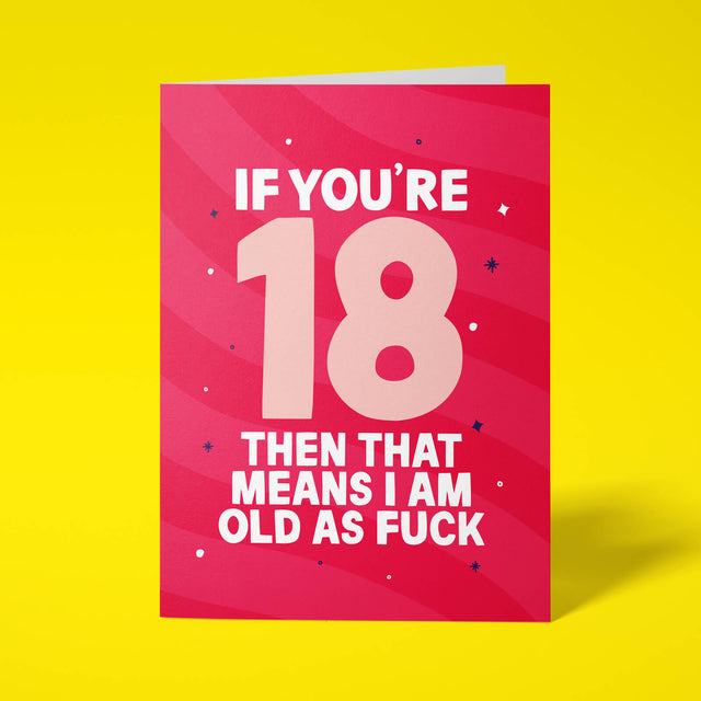 Raspberry pink rude 18th birthday card standing upright on a bright yellow background. White and pale pink chunky typography reads ‘IF YOU’RE 18 THEN THAT MEANS I AM OLD AS FUCK’ over pink wave stripes with navy and white sparkle details.