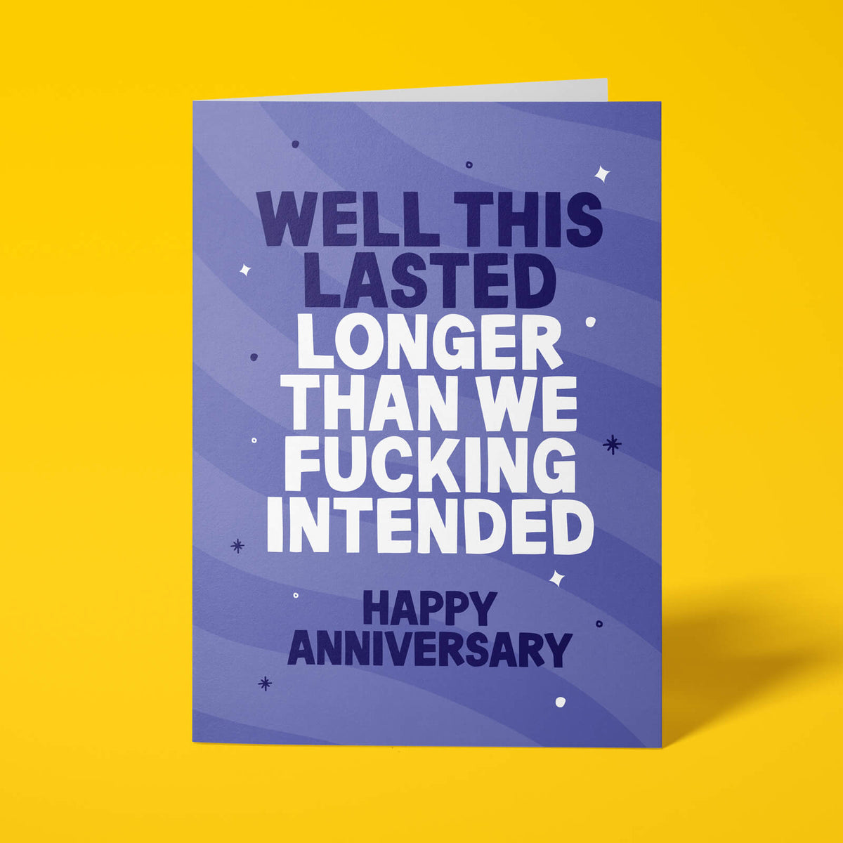 Purple anniversary card with white and lilac block-capital text reading "WELL THIS LASTED LONGER THAN WE FUCKING INTENDED, HAPPY ANNIVERSARY," decorated with hand-drawn stars, dots and sparkle icons.