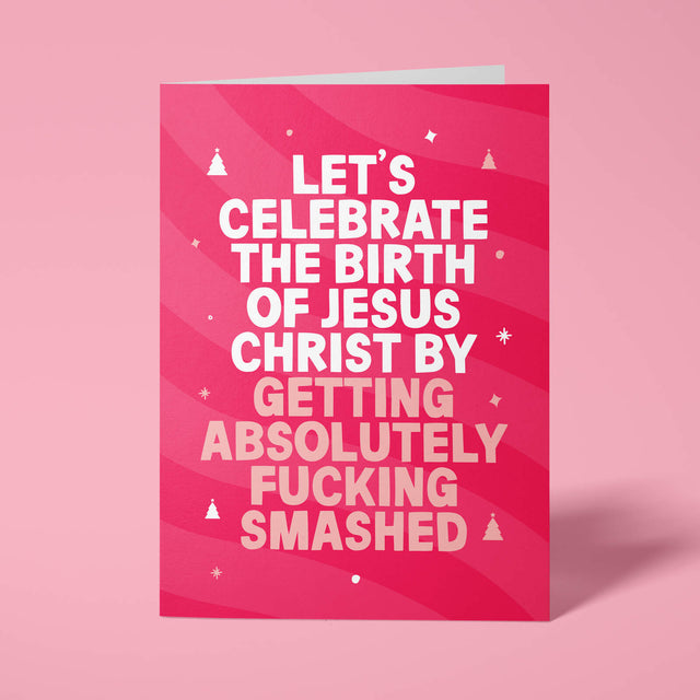 Raspberry pink rude Christmas card standing upright on a bright background. Bold white and pale pink chunky typography reads 'LET'S CELEBRATE THE BIRTH OF JESUS CHRIST BY GETTING ABSOLUTELY FUCKING SMASHED' over pink wave stripes with white and pale pink Christmas tree and sparkle details.