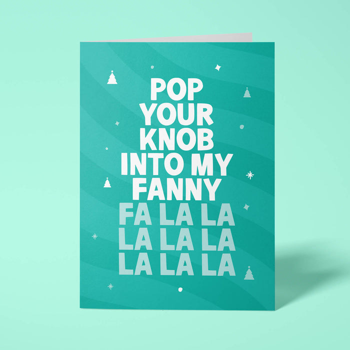 Green rude Christmas card standing upright on a bright background. Bold white and pale mint chunky typography reads 'POP YOUR KNOB INTO MY FANNY FA LA LA LA LA LA LA LA' over Green wave stripes with white Christmas tree and sparkle details.