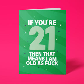 Green rude 21st birthday card standing upright on a bright pink background. White and pale mint chunky typography reads ‘IF YOU’RE 21 THEN THAT MEANS I AM OLD AS FUCK’ over green wave stripes with navy and white sparkle details.