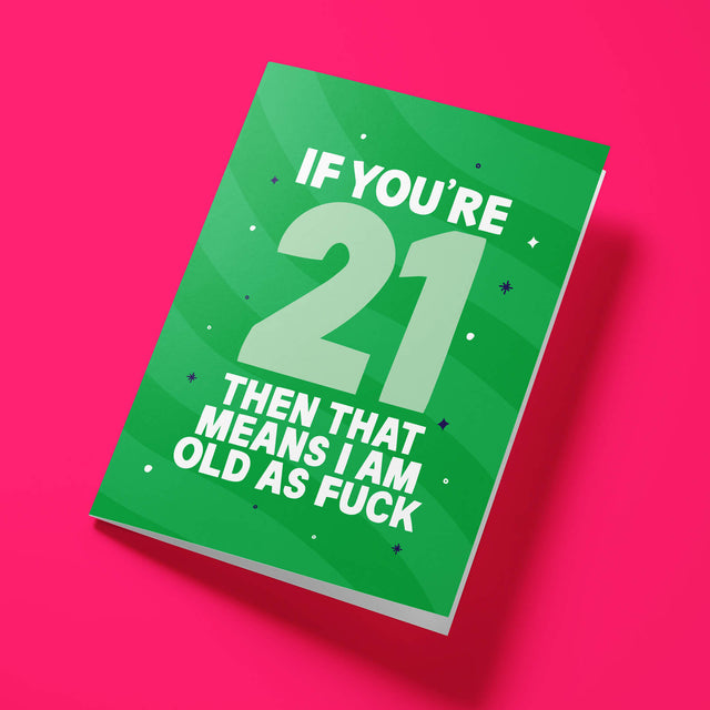 Green ‘Old As Fuck’ 21st birthday card laid flat at an angle on a bright pink background, with an oversized pale mint ‘21’ between white text.