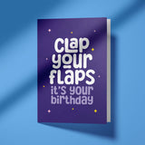 Greeting card with 'Clap your flaps, it's your birthday' text on a purple background