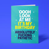 Funny birthday card reading 'Oooh Look At Me It's My Birthday Absolutely Fucking Pathetic' — teal background with yellow accent text, bold block design — Wottahoot