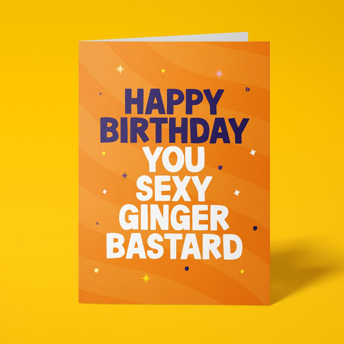 Orange rude birthday card with 'Happy Birthday You Sexy Ginger Bastard' message in dark blue and white lettering
