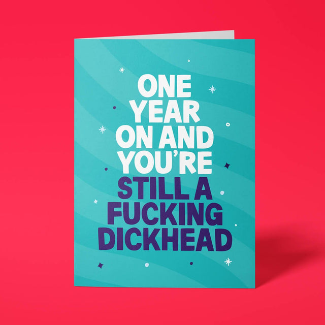 Teal rude birthday card with 'One year on and you're still a fucking dickhead' message in bold lettering