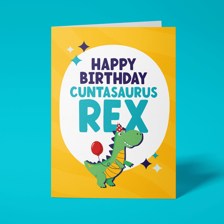 Rude birthday card reading 'Happy Birthday Cuntasaurus Rex' — yellow background with illustrated party dinosaur, bold navy and teal block text — Wottahoot