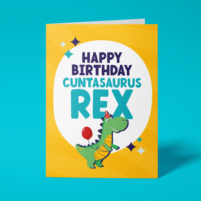 Rude birthday card reading 'Happy Birthday Cuntasaurus Rex' — yellow background with illustrated party dinosaur, bold navy and teal block text — Wottahoot